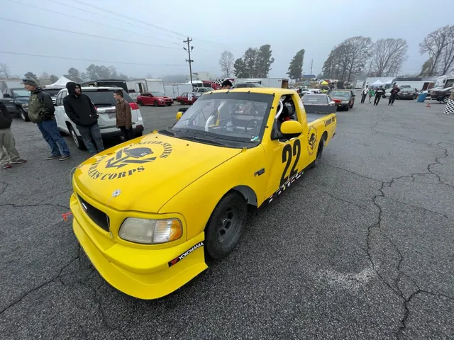 Lemon-Aid, a yellow race truck, in the paddock