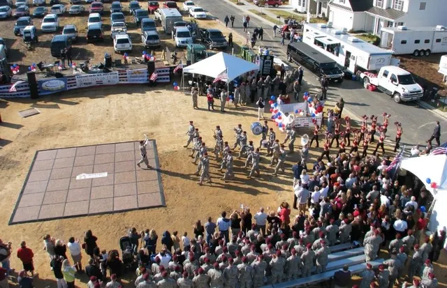 Aerial view of a crowd and a formation on a field at an outdoor ceremony
