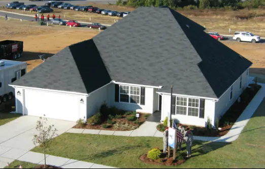 New single-story home with an American flag by the front walk