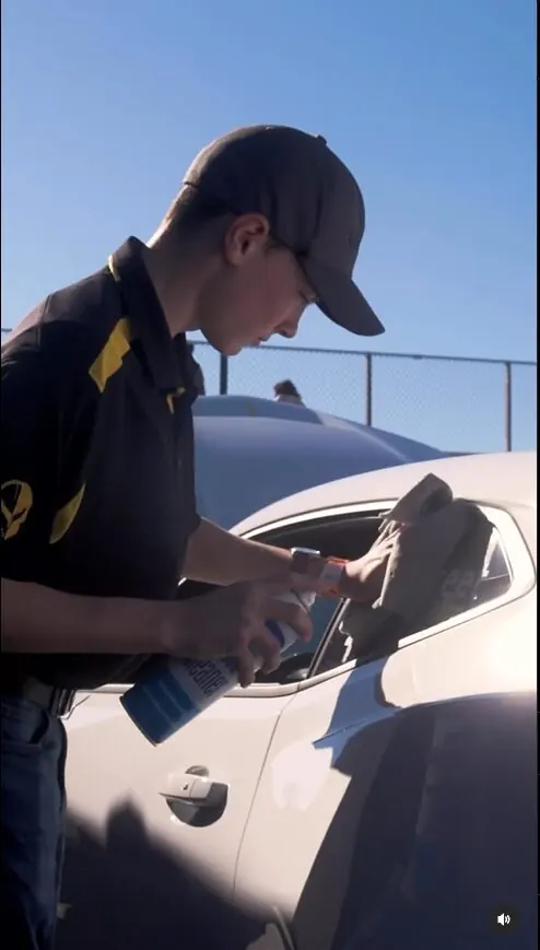Young driver in a helmet at the wheel of a junior dragster