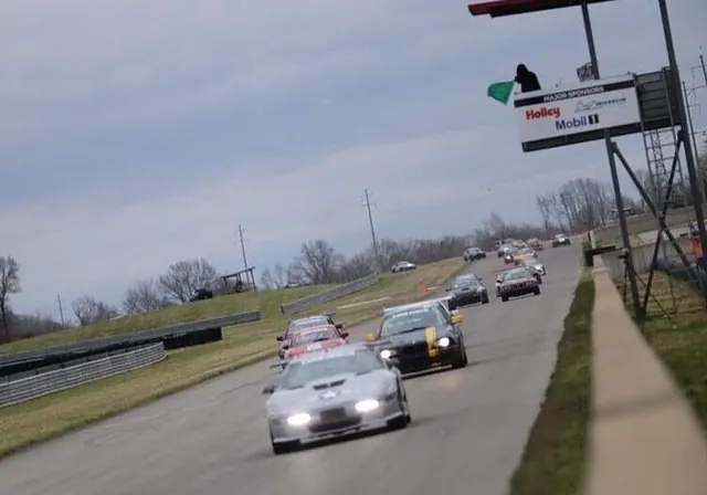 Race cars running nose to tail on a road course